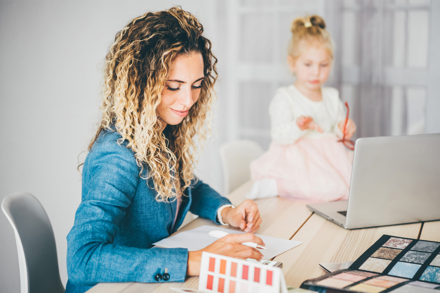 Business mom working at home with kid