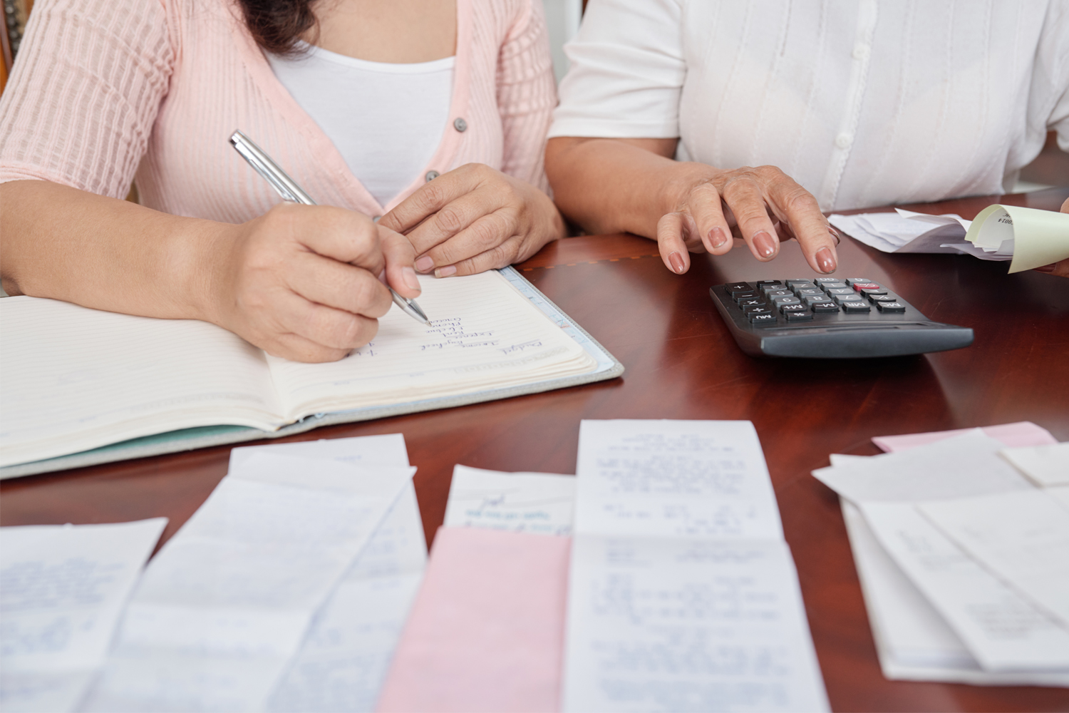couple calculating on table with receipts all over
