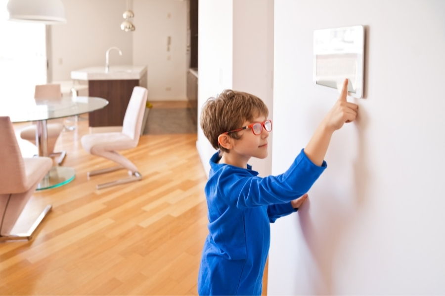 kid pressing button on smart home controls