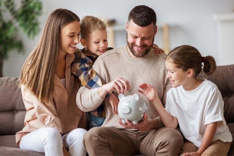 family inserting a coin in a piggy bank