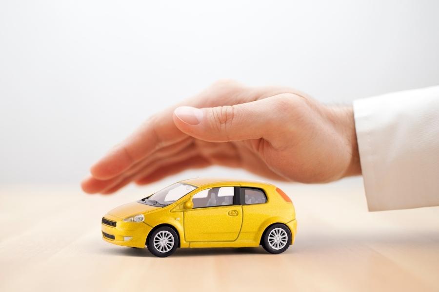 hand covering a yellow car